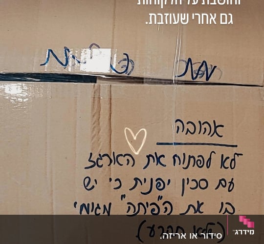 קופסה עם כיתוב בעברית ונעליים על רצפה